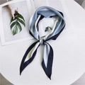 Pañuelo de seda a rayas azul marino y blanco anudado en lazo sobre una revista elegante - Rayas azul claro