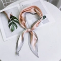 Pañuelo de seda a rayas rosa, blanco y gris anudado sobre una revista minimalista - Rosa Naranja a Rayas