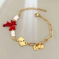 Golden chain bracelet featuring red coral charms, white beads, and tiny footprint pendants - Feet Paperclip Style