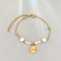 Golden beaded pearl bracelet featuring white pearls and a celestial sun moon coin charm - Star Moon Style