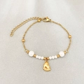 Gold beaded bracelet featuring white pearls and a small baby feet pendant design - Paw Print