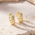 Close-up of gold double-layer hoop earrings with heart-shaped zircons and hollow details - Heart Zirconia Hoop