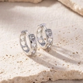 Close-up of silver hoop earrings featuring sparkling inlaid heart-shaped patterns - Linked Heart Hoop Diamond