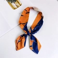 Floral twilly scarf in orange and navy blue, styled as a bow on a white background - Apricot Blossom Orange
