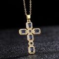 Vue macro du collier croix dorée orné de gemmes bleues et de détails en zircon blanc - Style Bleu Foncé