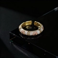 Dettaglio macro di anello vintage dorato con smalto bianco e accenti di zirconi lucidi - Stile Smalto Bianco (B)