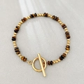 Bohemian tiger eye stone beaded bracelet with golden toggle clasp on grey fabric - Natural Yellow Tiger Eye