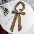 Elegante foulard in seta con stampa leopardata annodato a fiocco su scrivania bianca - Stampa Leopardata Gialla