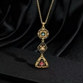 Dettaglio ravvicinato di una collana vintage dorata con pietre preziose colorate - Pendente Palazzo Vintage con Gemme Rosse Blu Bianche (K)