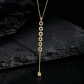 Dettaglio collana nappa placcata oro con pendenti quadrati in zircone su sfondo roccia - Pendente Micro-set Geometrico Quadrato (S)