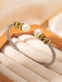Dettaglio del bracciale a cavo con perle e pavé di cristalli su portagioie in legno - Bicolore (Oro e Argento)
