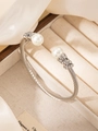 Dettaglio del bracciale a cavo d'argento con perle e anelli pavé di diamanti brillanti - Color Acciaio