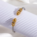 Silver twisted cable cuff bracelet with gold-tone rhinestone ends on white display - Pointed End Cable Style / Two-Tone Gold & Silver (szgss130)