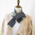 Knitted navy blue scarf with green polka dots on a mannequin for winter style - Blue