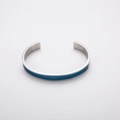 Detail van de C-vormige roestvrijstalen armband met blauwe mesh-inlay en matte afwerking - Blauw