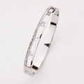 Macro detail of silver bangle featuring hollow Roman numerals and side pavé rhinestones - Steel