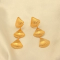 Detalle de pendientes de concha chapados en oro de tres niveles sobre seda de color beige - Estilo de Triple Concha Colgante / Dorado