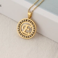 Golden round pendant necklace with letter E and sparkling crystal pavé stones - Letter E