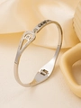 Vista macro del bracciale in acciaio al titanio argento con goccia d'acqua e pavé di zirconi - Oro 18K / Argento