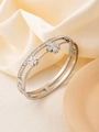 Detailed macro view of silver clover bangle featuring clear crystals and double frame design - 18K Gold / Silver