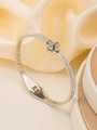 Detailopname van een zilveren roestvrijstalen armband met pavé-kristallen en een klavertje - 18K goud / Zilver