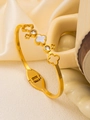 Detail of 18K gold clover bangle with white shell inlay and sparkling zirconia accents - White Mother of Pearl Clover Style / Gold