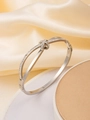 Detailed view of silver bow-knot bangle with pavé crystals on a silk display - Silver