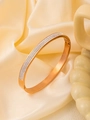 Détail du bracelet en titane or rose avec trois rangées de zircons sur du tissu - Or 18K / Or rose