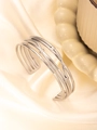Detail des mehrlagigen Silberarmbands mit geflochtenen Texturen auf Seidenhintergrund - 18K Gold / Silber