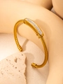 Makro-Detail des goldenen Seil-Armreifs mit funkelndem Pavé-Diamant-Rechteck-Element - Gold