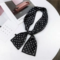 Satin polka dot twilly scarf in black and white tied as a bow on a display surface - Black with Polka Dots