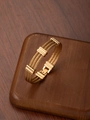 Macro shot of 18k gold plated stainless steel triple cable bracelet with industrial accents - Gold