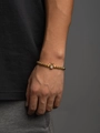 Men's gold beaded bracelet featuring a sparkling zircon crown charm on wrist - Gold