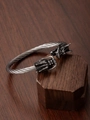 Macro detail of dual dragon heads on a stainless steel braided wire cable bracelet - Steel
