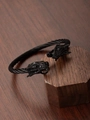 Macro shot of dual dragon head ends on a black wire rope bracelet with a C-shape design - Black