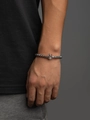 Minimalist stainless steel beaded bracelet featuring crown pendant on male model wrist - Silver