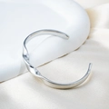 Eleganter silberner Mobius Armreif aus 18k vergoldetem Edelstahl mit poliertem Design - Stahlfarbe