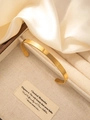Detailopname van een minimalistische 18k vergulde roestvrijstalen C-vormige manchete armband - Goud