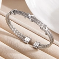 Bracciale rigido a cavo ritorto argento con motivi a X lucidi e terminali scanalati di lusso - Color Acciaio