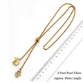 Detalle del collar Mano de Fátima y candado de 80cm con cadena de bolas doradas de 2,5mm - Cadena de Suéter en Forma de Candado