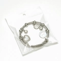 Close-up of a silver twisted cable bangle featuring heart and moon star charms - Steel