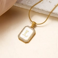 Goldene Halskette mit L-Anhänger, Muscheleinlage und glitzerndem Kristallrahmen - L