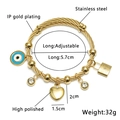 Dettaglio del bracciale in filo d'acciaio dorato con ciondoli occhio e cuore - Oro