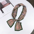 Houndstooth silk scarf in orange and blue tied as a bow on a minimalist white table - Houndstooth Green Edge