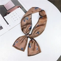 Elegant brown plaid and floral satin skinny scarf tied in a bow on a white table - Floral Houndstooth Orange