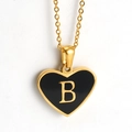 Close-up of golden heart pendant with black inlay and letter B on a delicate O-chain - Black - Letter B