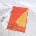 Two-tone scarf in orange and ginger yellow with tassels displayed on a wooden floor - Orange