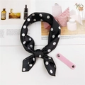 Dettaglio flatlay di un foulard in seta nero a pois bianchi annodato con stile elegante - Nero a Pois