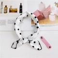 Dettaglio di un foulard in seta a pois con cinturino in pelle rosa su una rivista - Bianco a Pois