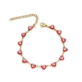 Dettaglio del bracciale dorato con ciondoli a cuore rossi, motivo malocchio e chiusura a moschettone - Rosso